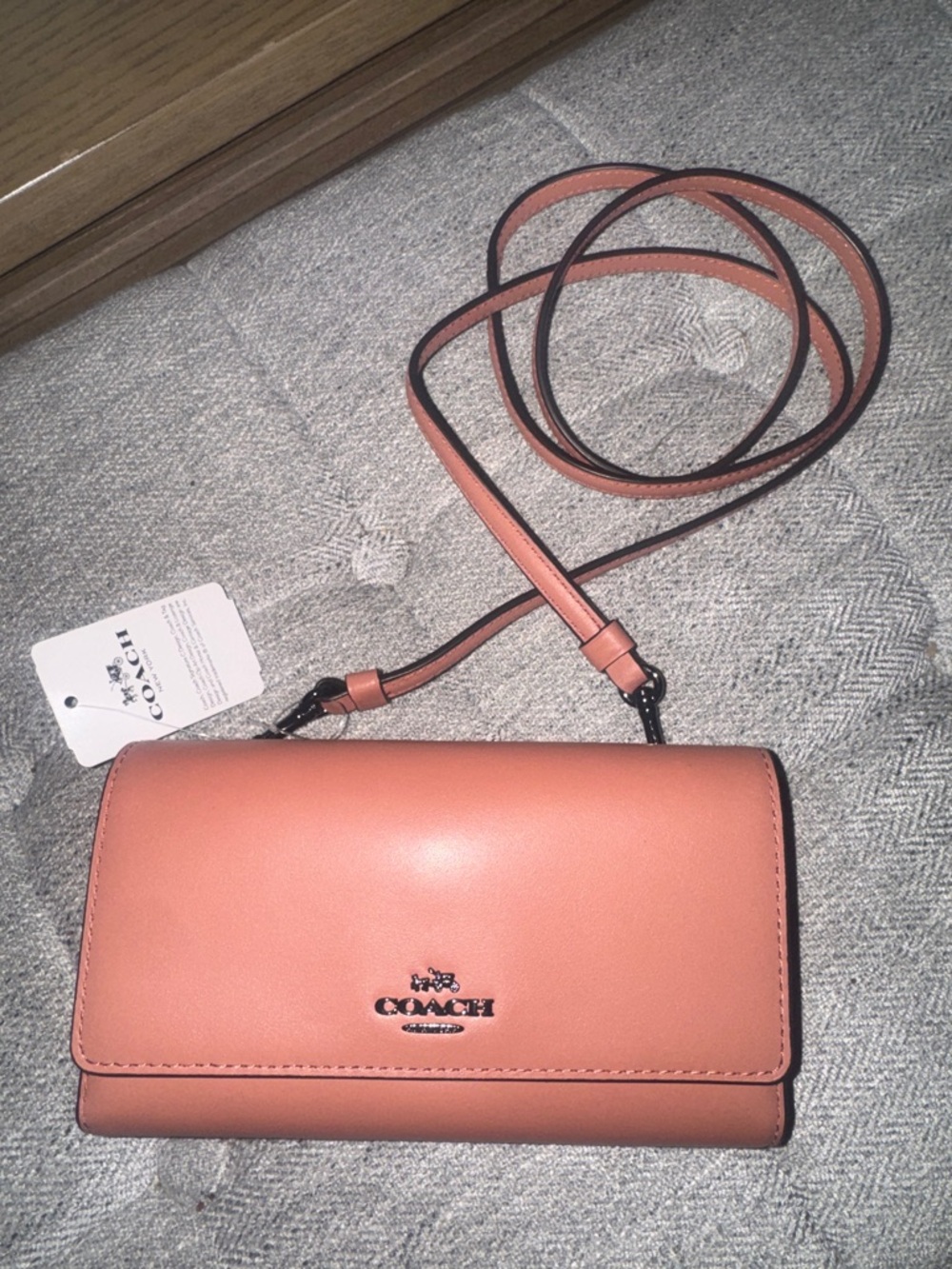 NWT, Coach  phone snap crossbody in smooth leather in a dark melon.